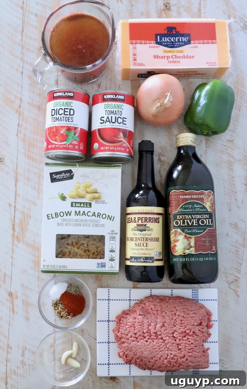 ingredients for American goulash laid out on a white wood board