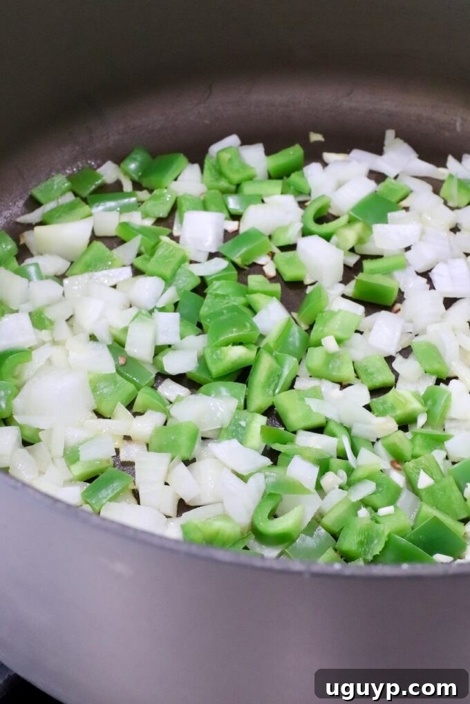 diced onions and green bell peppers sauteeing in a large pot