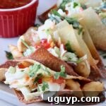 wonton taco shells filled with cooked chicken and coleslaw on a plate