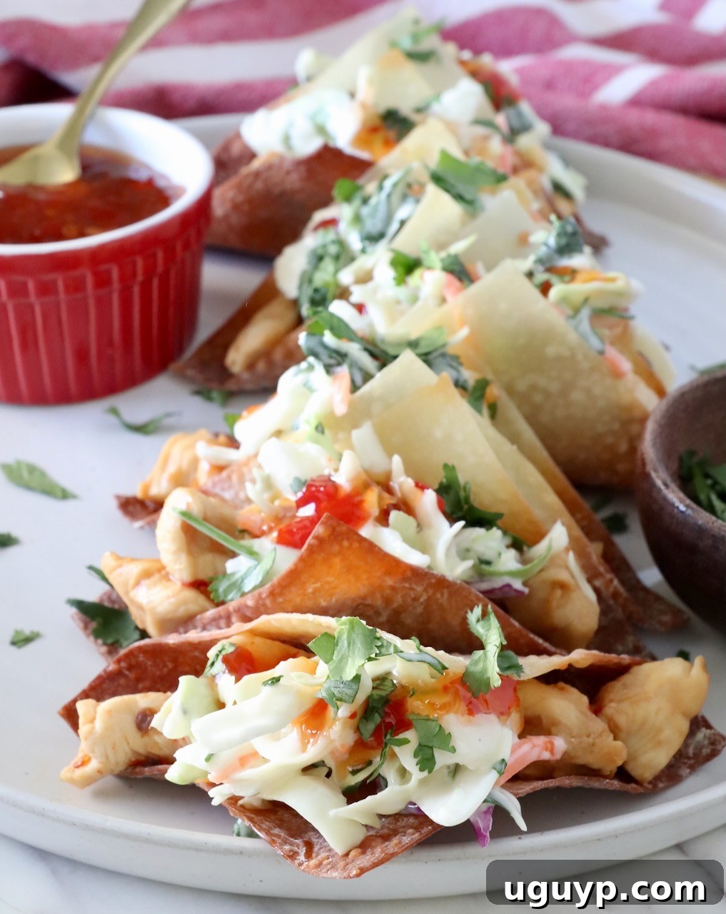 chicken wonton tacos topped with sweet chili sauce on a plate