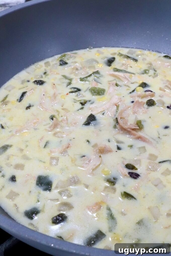 The finished creamy Chicken Poblano Soup, rich and smooth, ready to be served from a large pot.