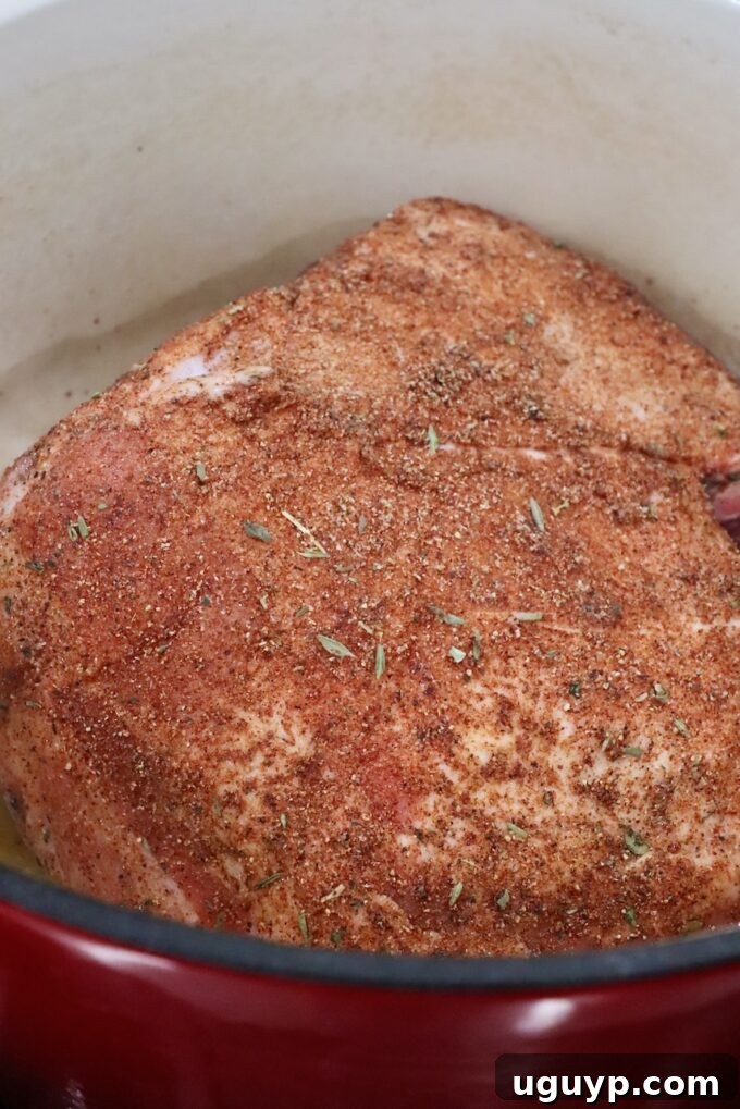 seasoned pork shoulder in a large cast iron pot