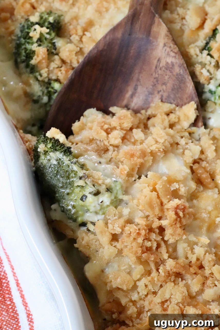 creamy casserole topped with a cracker topping in a casserole dish with a serving spoon, showcasing the rich texture and golden crust