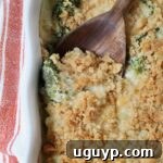 baked casserole with a cracker topping in a baking dish with a serving spoon