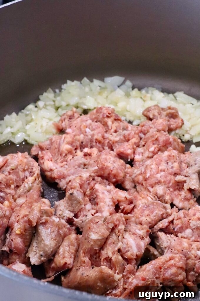 diced onion in a large pot with loose Italian sausage