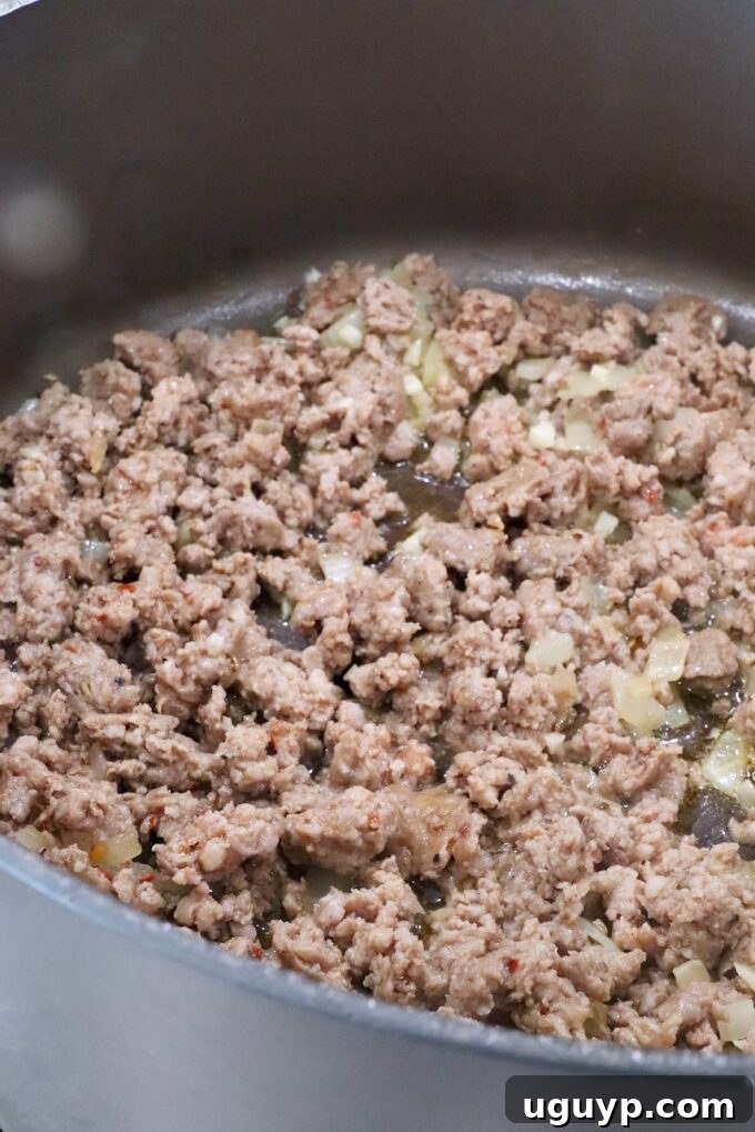 cooked sausage and onions in a large pot