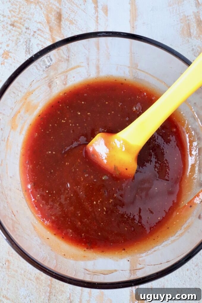 meatloaf glaze in a glass bowl with a yellow spatula