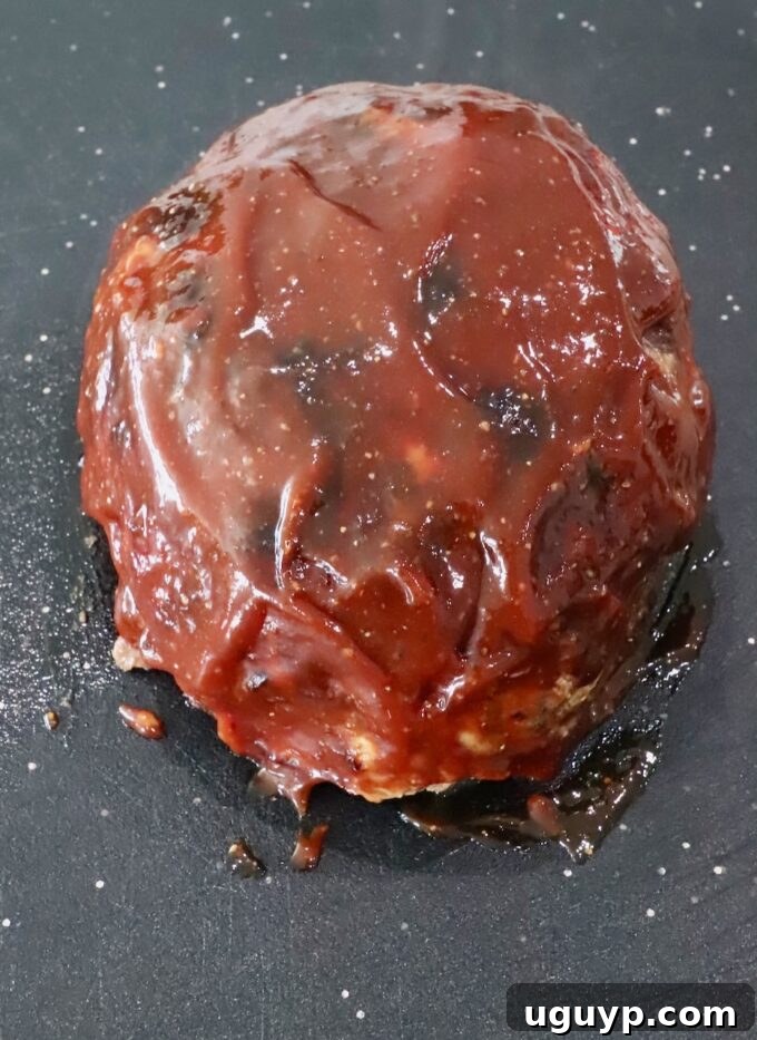 cooked, glazed meatloaf on a cutting board