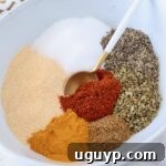 dried herbs and spices separated in a bowl with a spoon