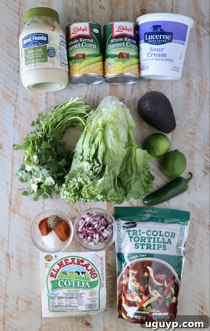 Fresh ingredients for Mexican street corn salad laid out on a white wooden board