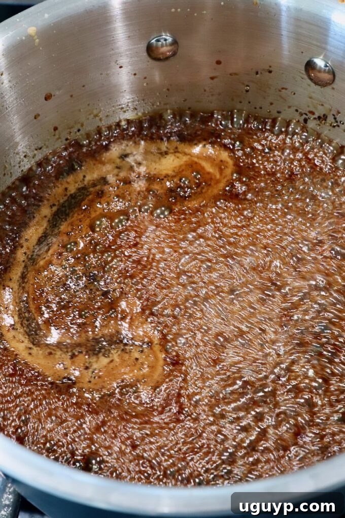 Korean BBQ sauce gently simmering in a saucepan on the stove, its rich, dark color indicating developing flavors.