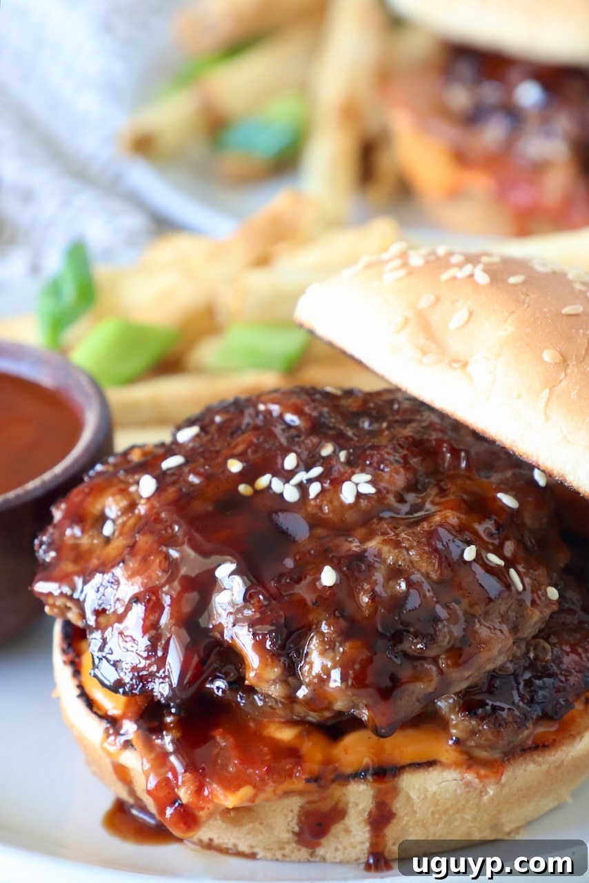 korean bbq burger on a bun on a plate, with the top bun leaning on the side of the burger