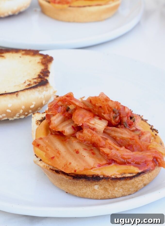 hamburger bun on a plate topped with gochujang mayo and kimchi