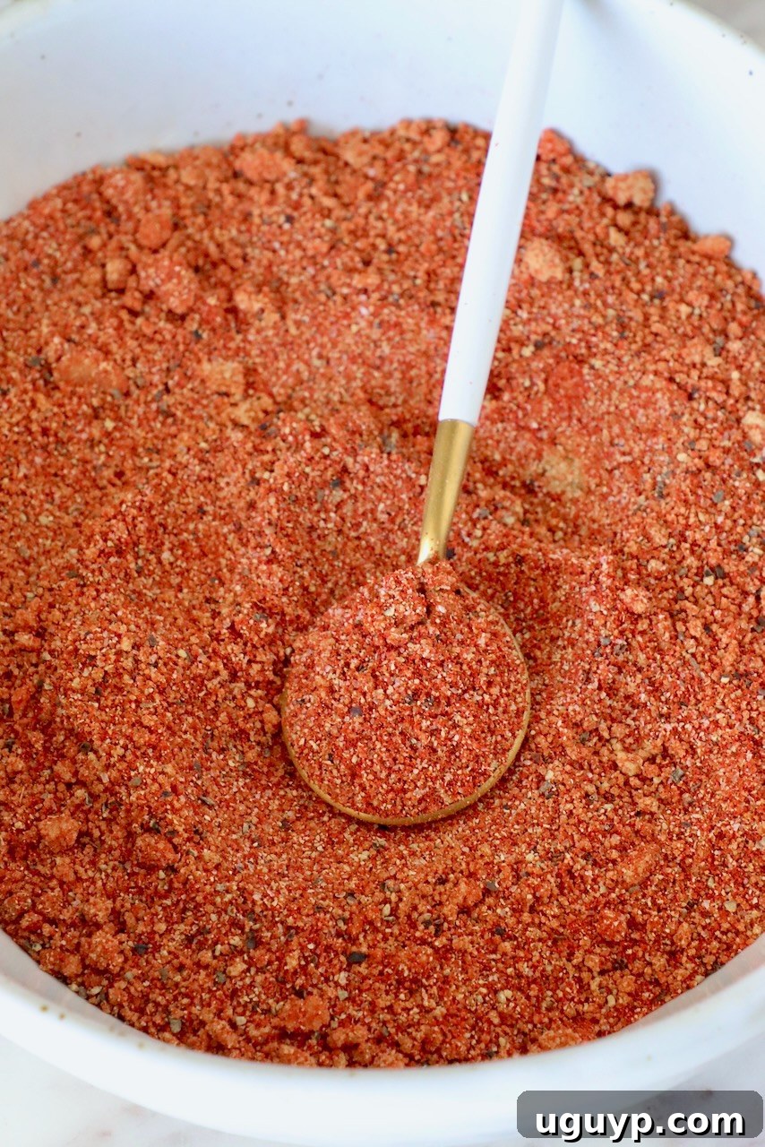 A close-up shot of a bowl filled with a rich blend of Korean BBQ spices, with a spoon resting inside, highlighting the vibrant colors and textures of the seasoning mix.
