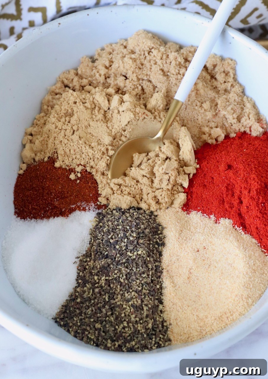 A beautifully composed shot of spices and brown sugar thoughtfully separated within a single bowl, awaiting mixture, with a spoon nearby, highlighting the individual components before they become the Korean BBQ seasoning.