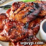 bbq glazed grilled chicken stacked up on a plate