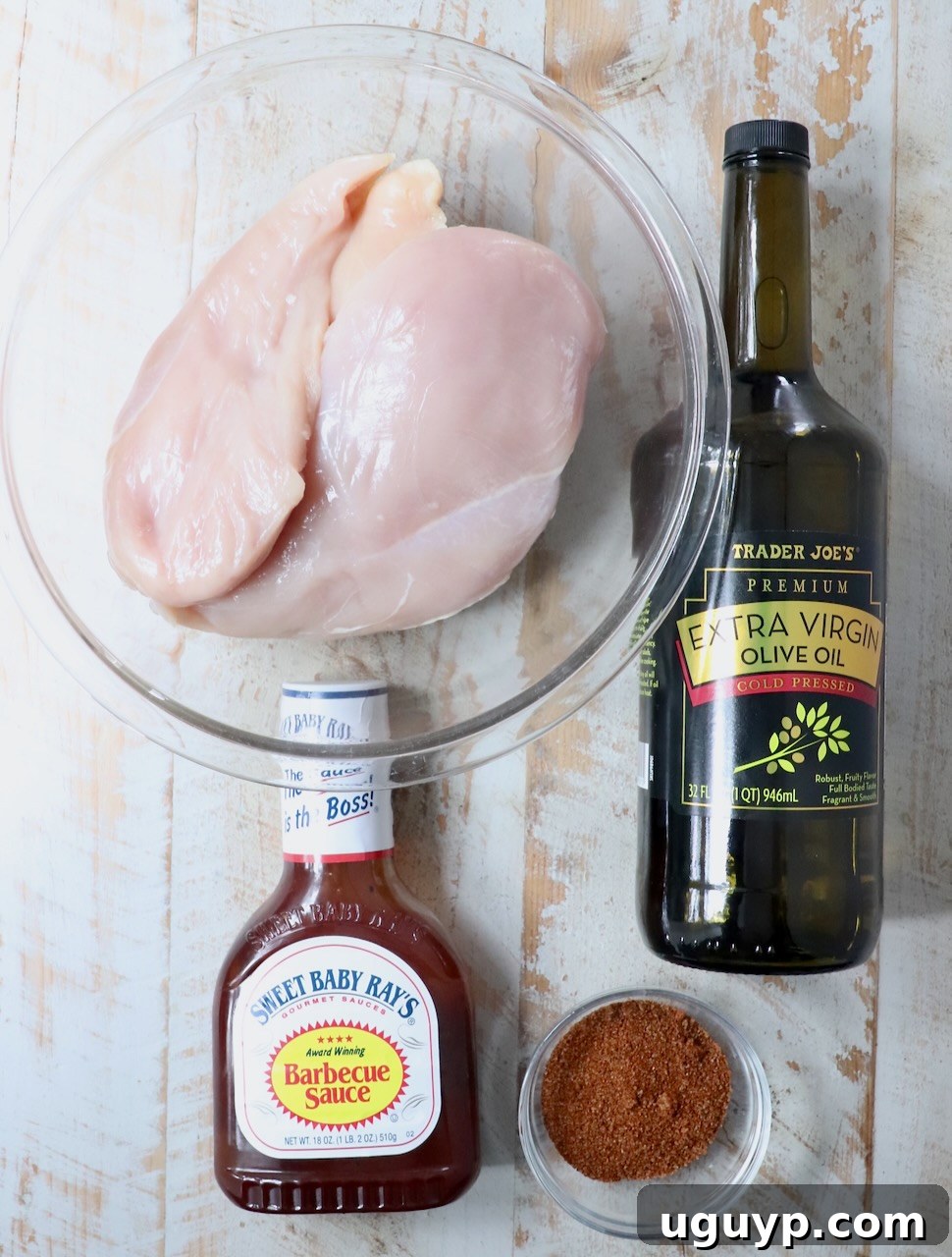 ingredients for smoked chicken breasts on a white wood board