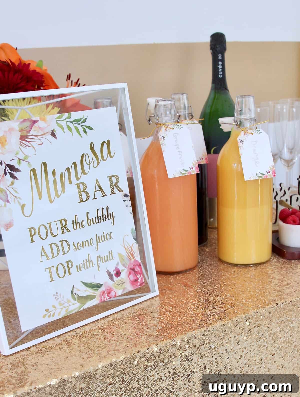 Mimosa bar sign with elegant gold sparkly tablecloth and an array of fresh juices