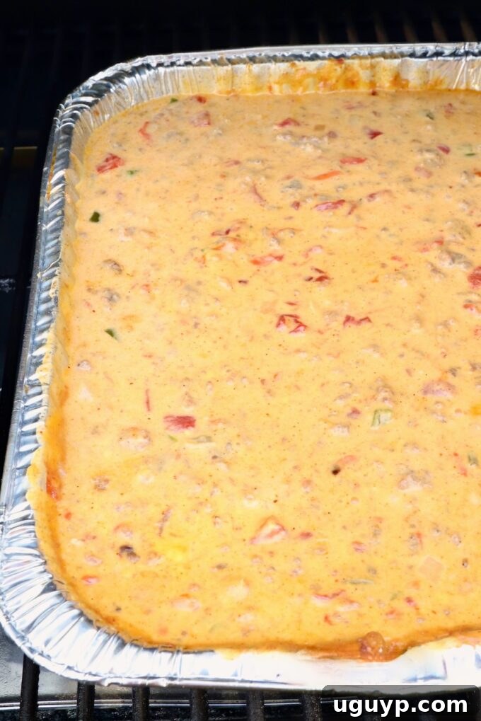 queso dip in an aluminum pan on a smoker