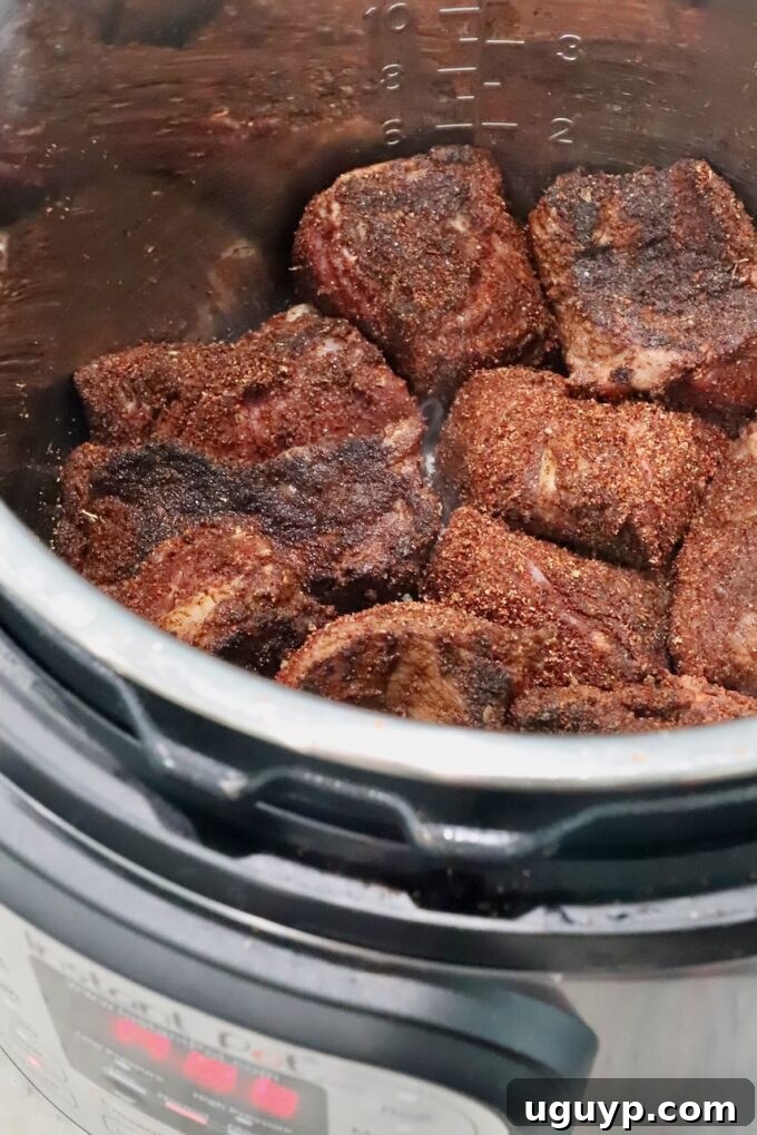 Seared pieces of seasoned beef browning beautifully in the Instant Pot, forming a delicious crust.
