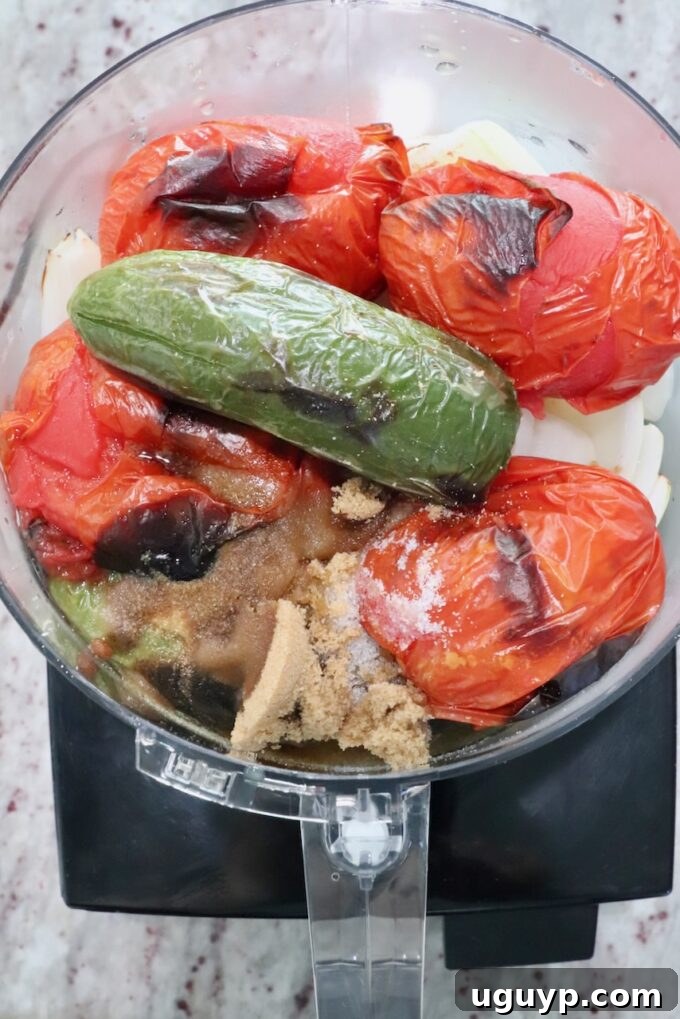 roasted tomatoes and peppers in a food processor, ready to be blended