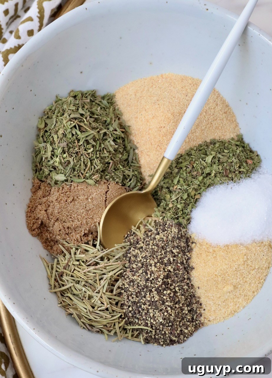 dried herbs and spices separated in a bowl with a spoon, highlighting the rich colors and textures of a homemade lamb seasoning blend