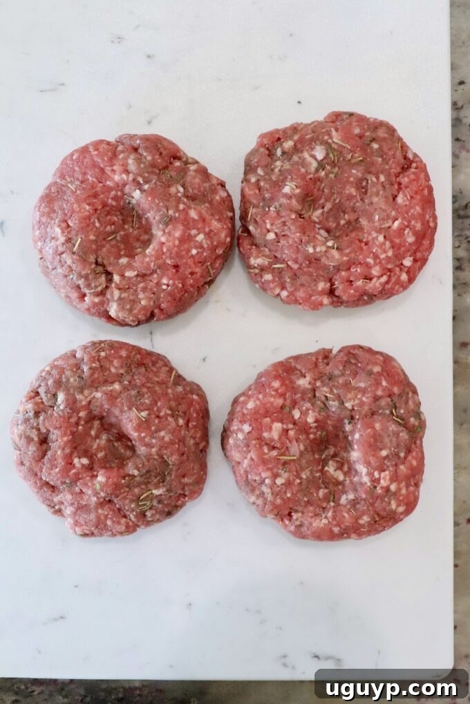 lamb burger patties on a white cutting board