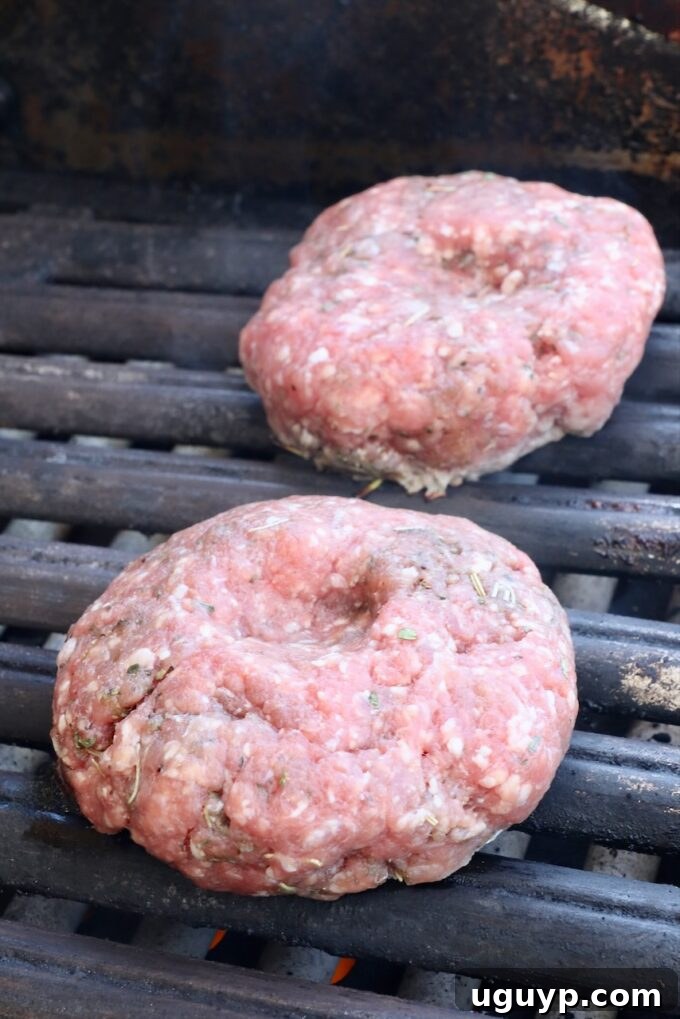 raw lamb burger patties on a grill