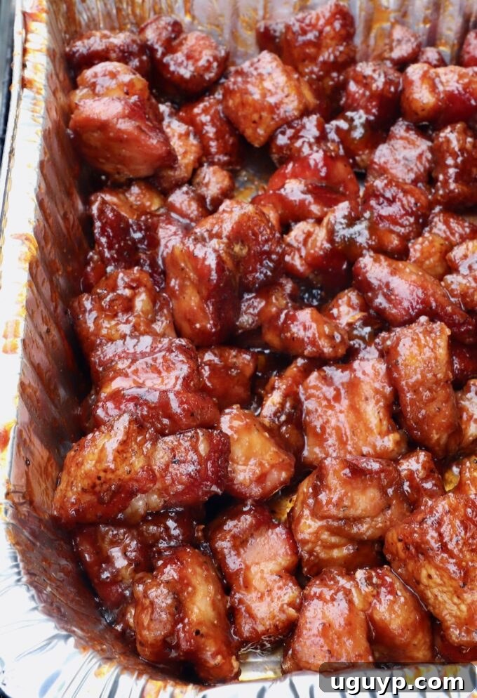 Smoked cubes of pork belly in a foil pan tossed in a BBQ glaze.