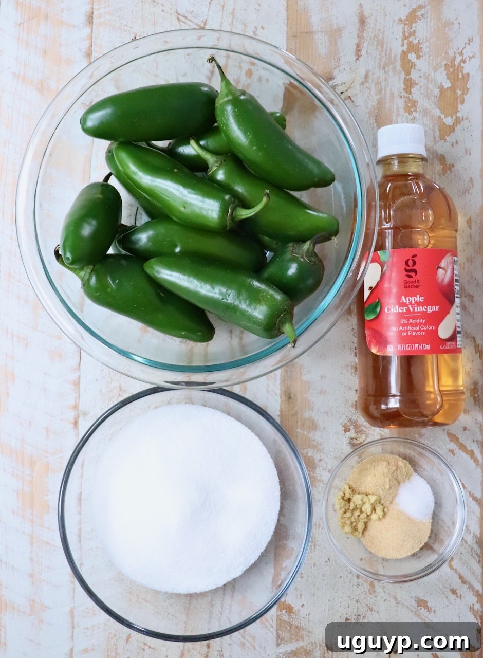 ingredients for candied jalapenos on a white wood board