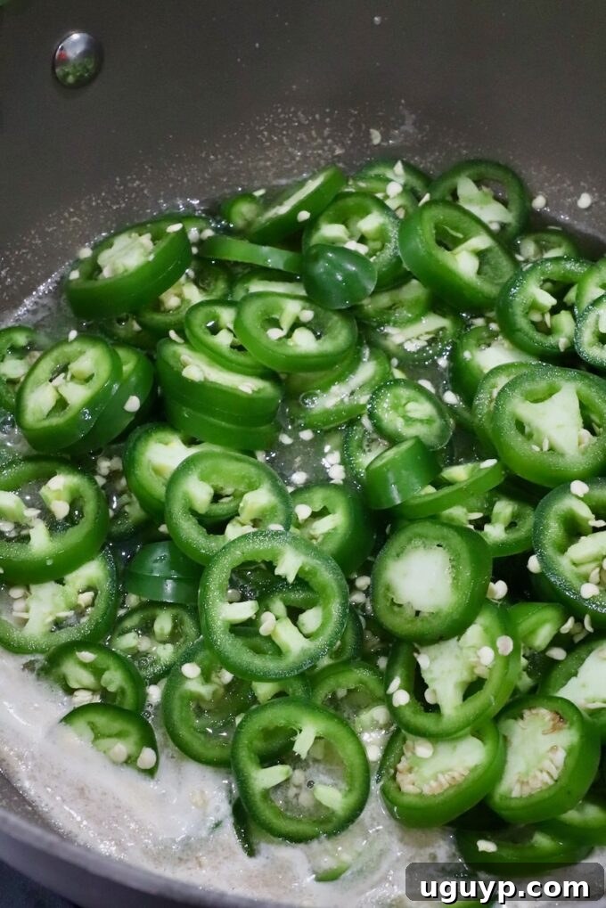 sliced jalapenos in a pot of boiling liquid