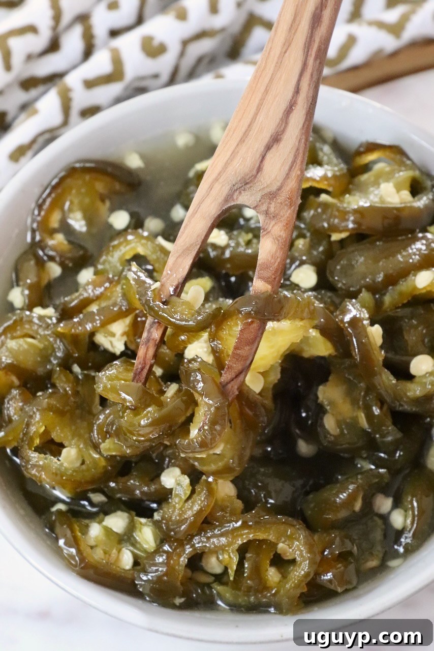 candied jalapenos in a bowl with a wooden fork