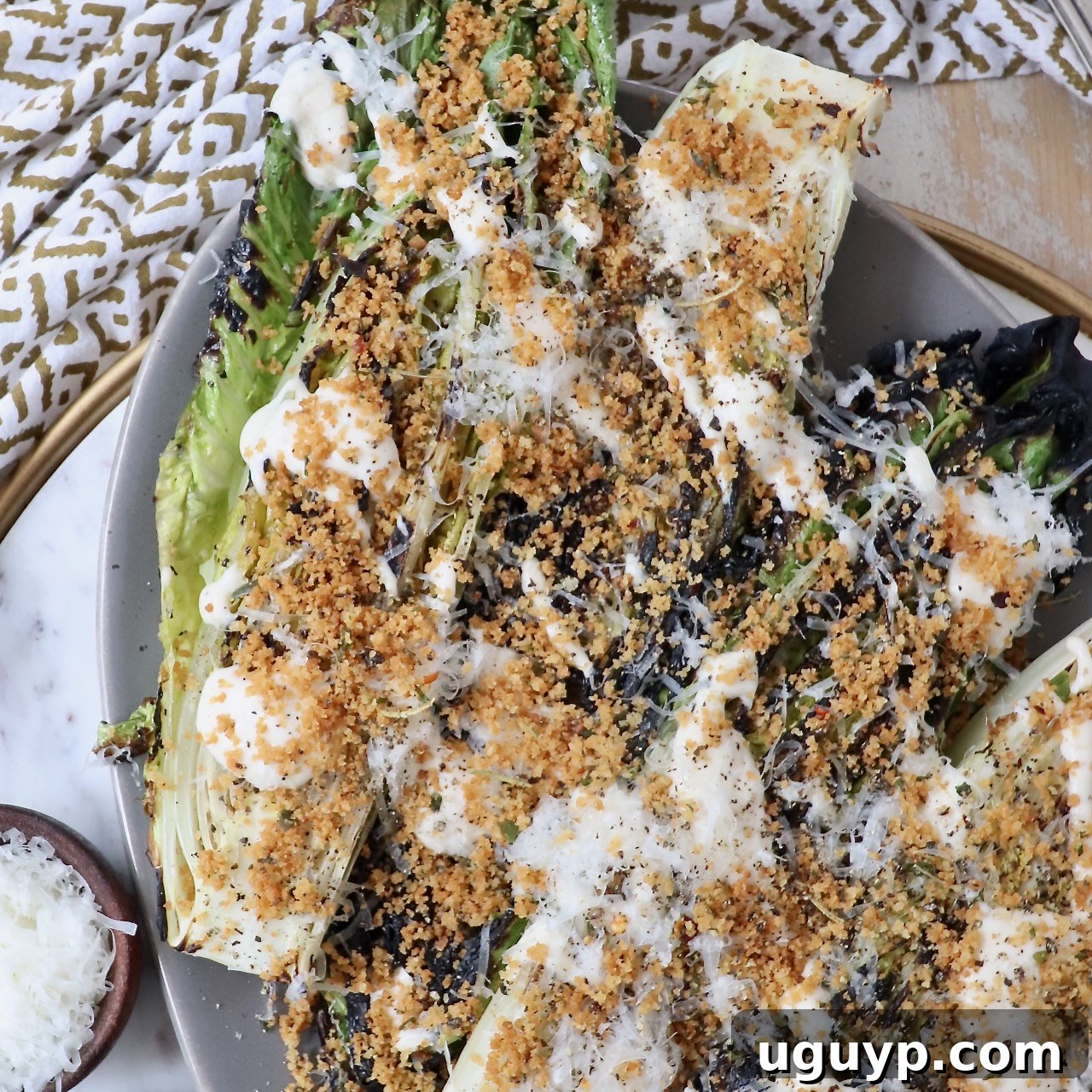 A vibrant grilled romaine lettuce Caesar salad on a plate, generously topped with crispy toasted breadcrumbs, offering a smoky twist on a classic.