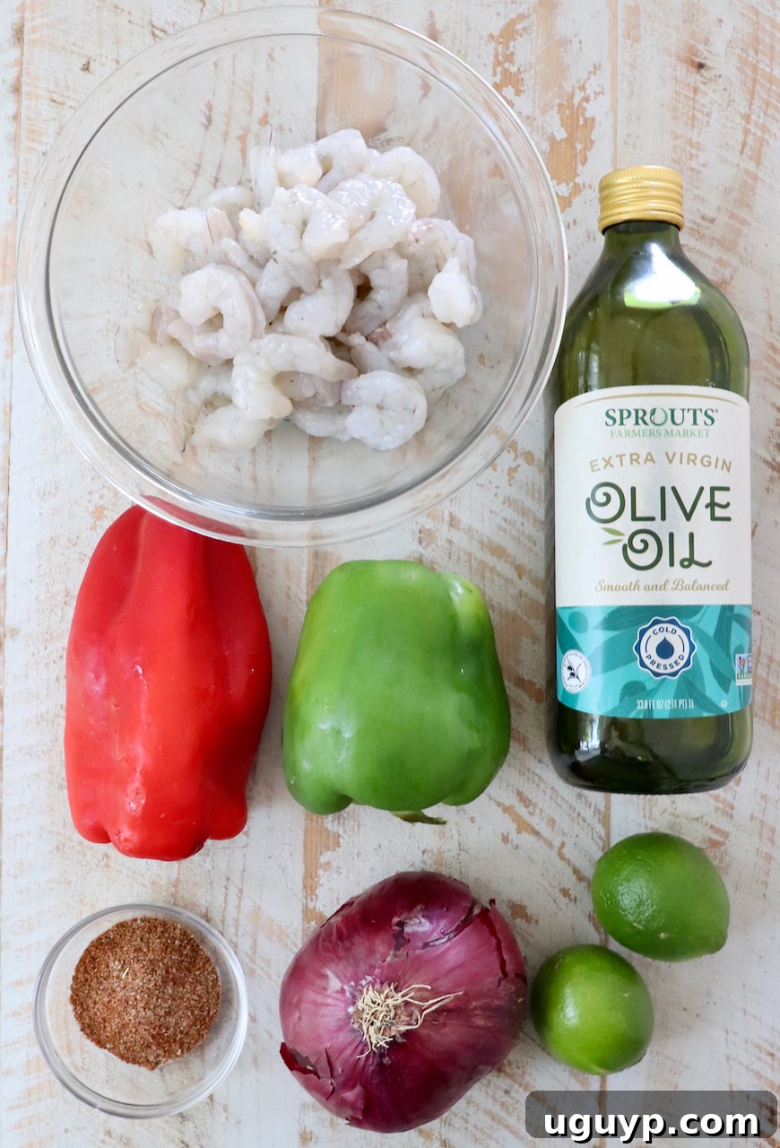 Ingredients for shrimp fajitas laid out on a white wooden board.