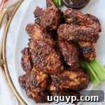 cooked chicken wings tossed in bbq sauce piled up on a plate
