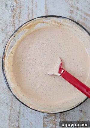 creamy Cajun sauce mixed together in a glass bowl with a red spatula