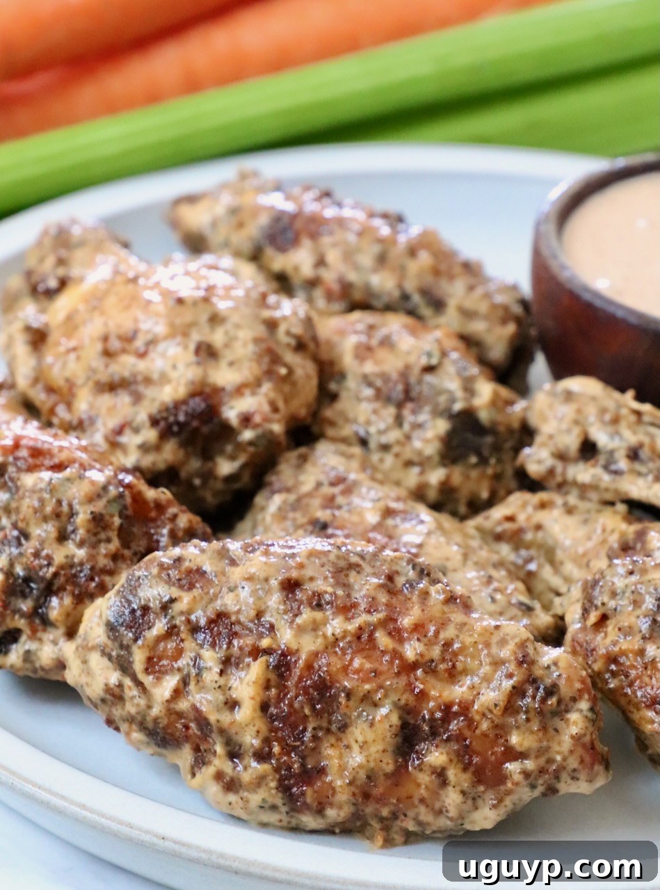 cooked chicken wings tossed in a creamy sauce on a plate