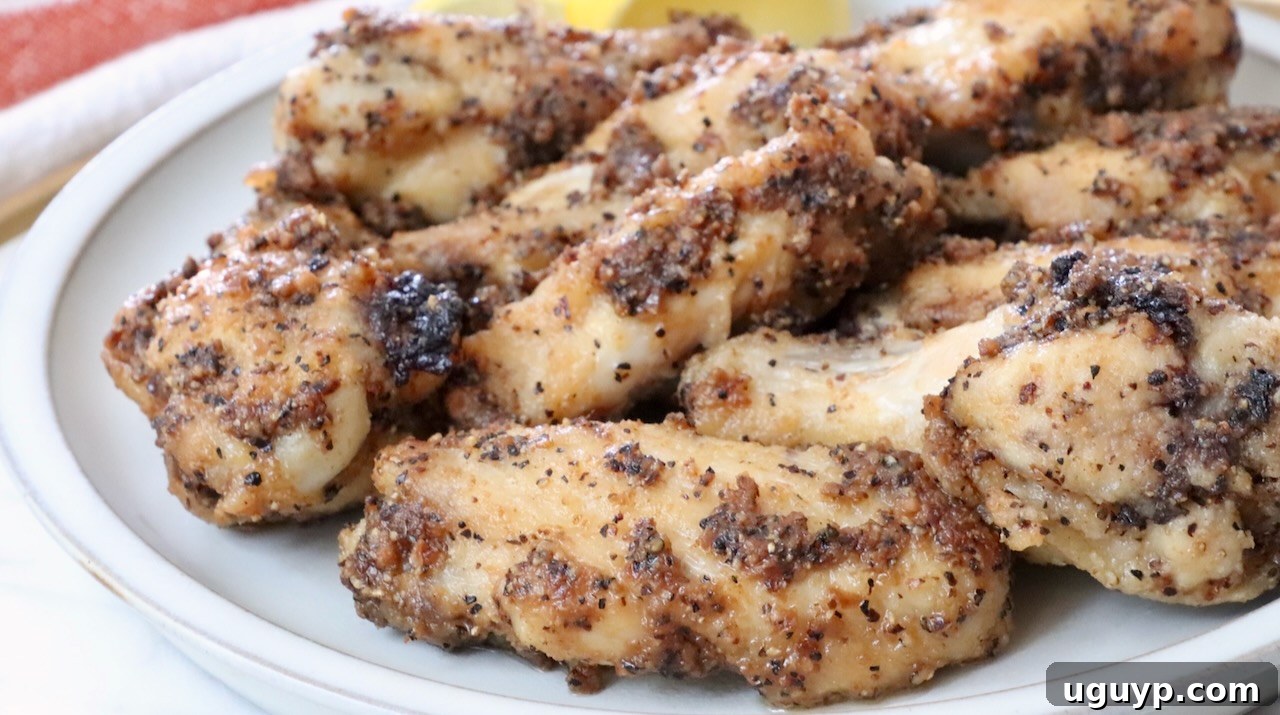A stack of golden brown, crispy lemon pepper wings ready to be served.