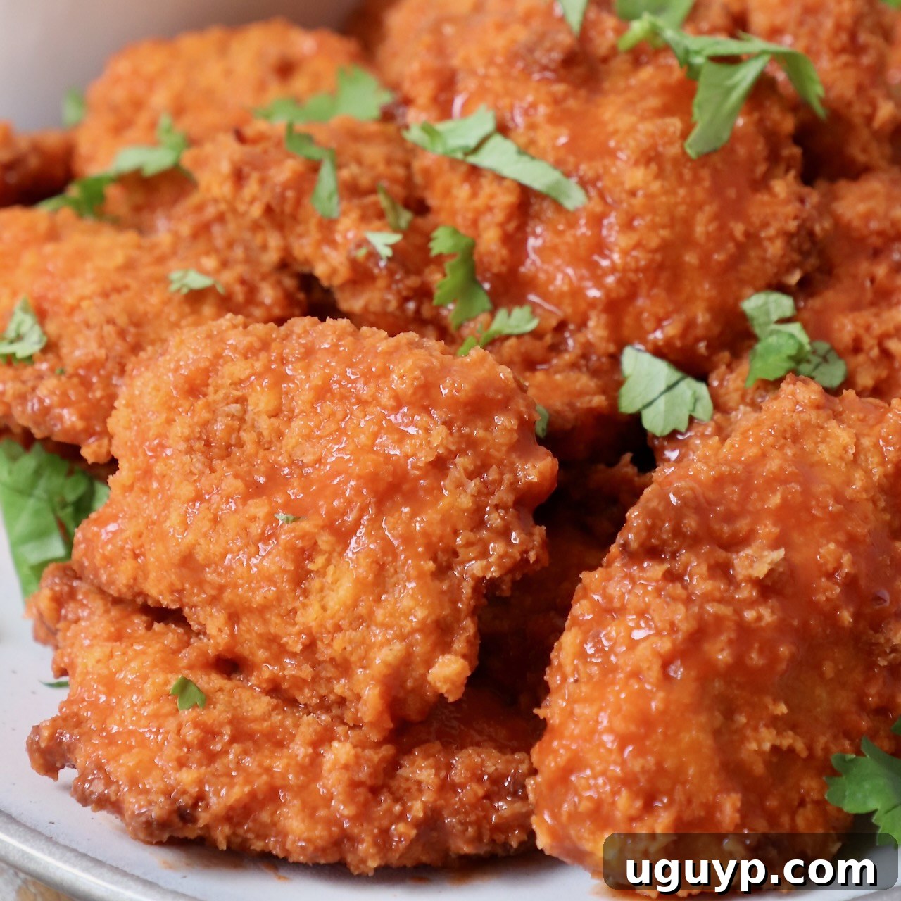 boneless chicken wings tossed in buffalo sauce on plate