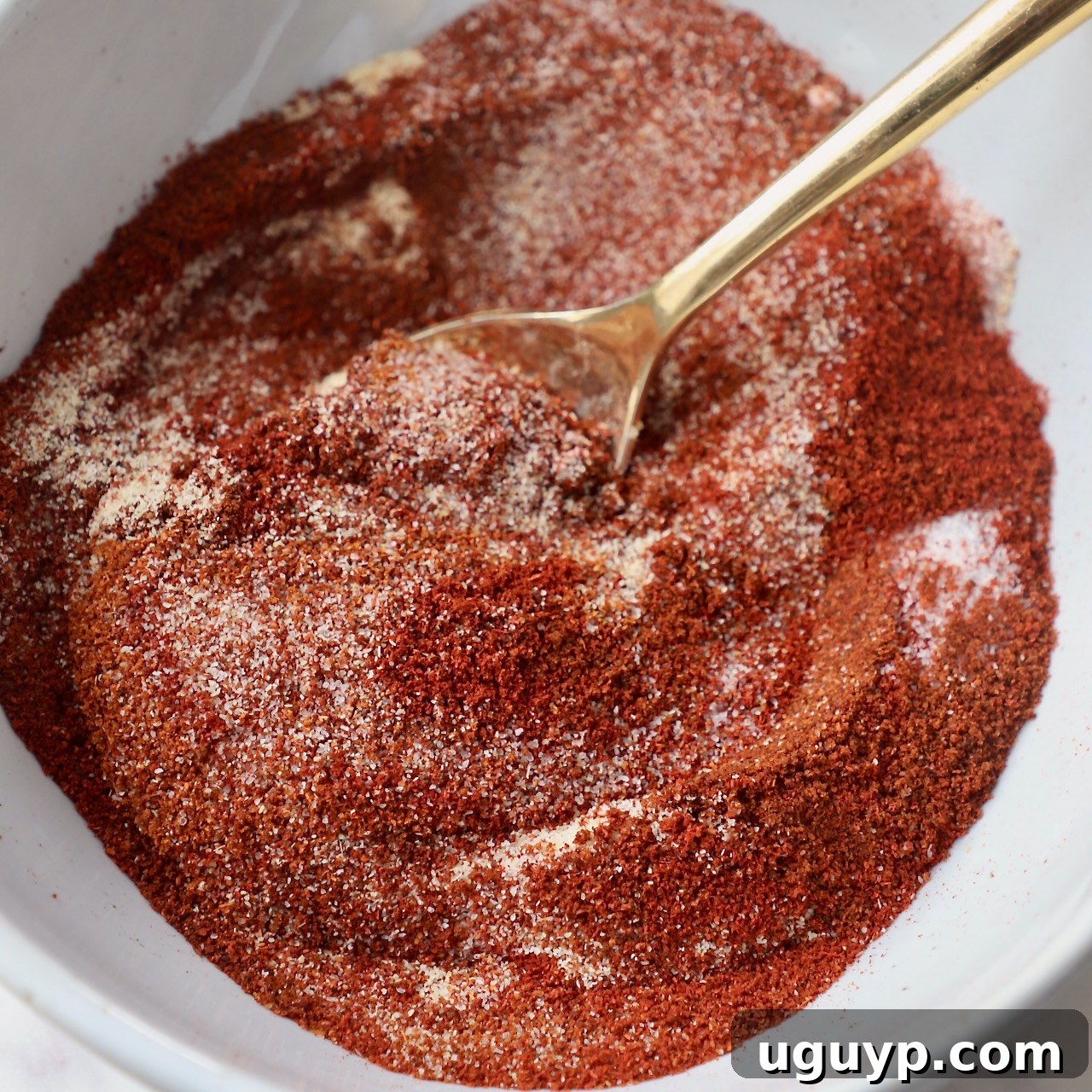 chicken wing seasoning in white bowl with gold spoon
