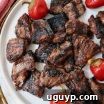 Grilled steak bites on a plate with cherry peppers