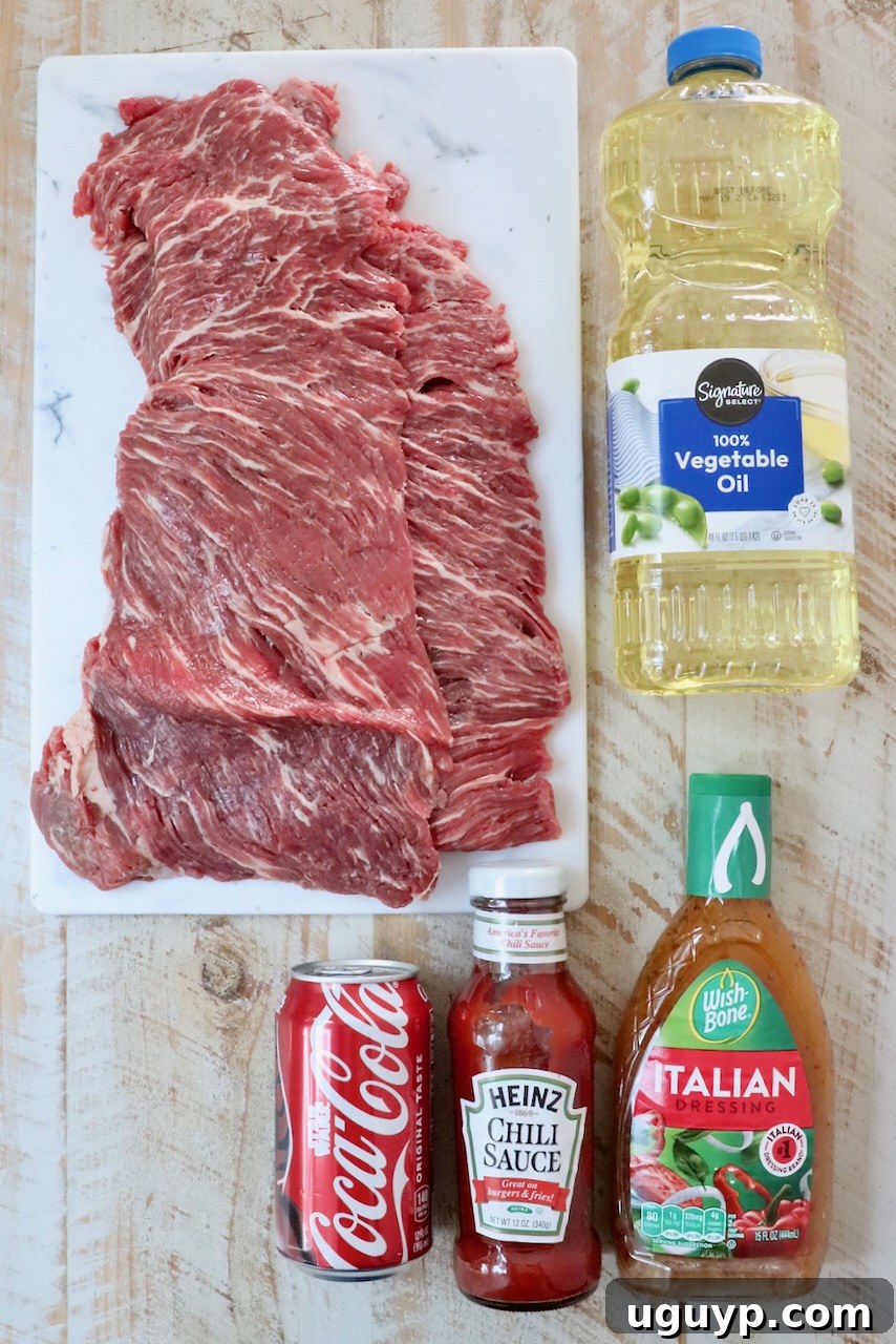 A collection of ingredients for the steak tips recipe, artfully arranged on a white wooden board.