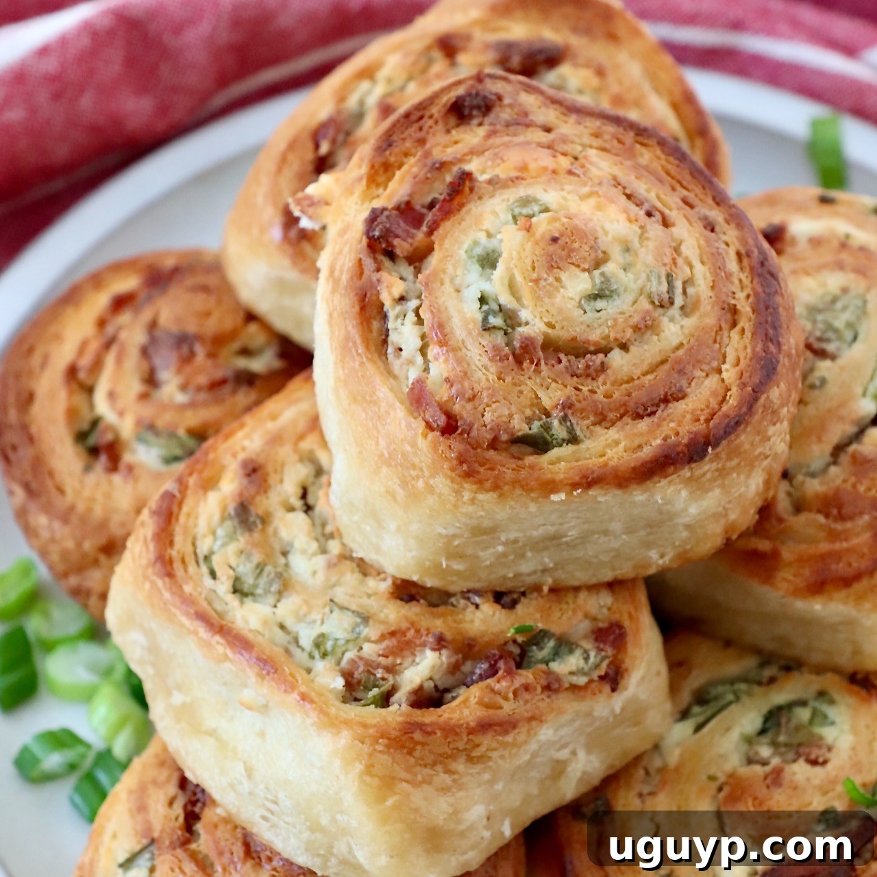 Baked Cheesy Bacon Crescent Rolls stacked up on a plate.