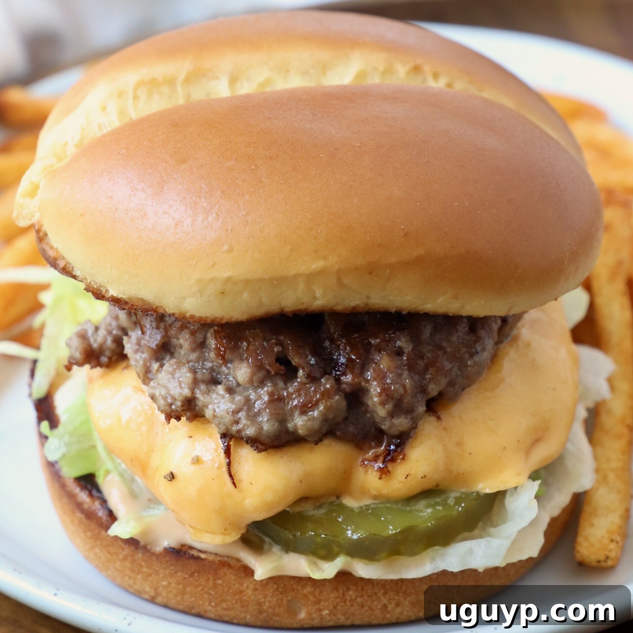 Delicious Smash Burger on a plate with crispy fries.