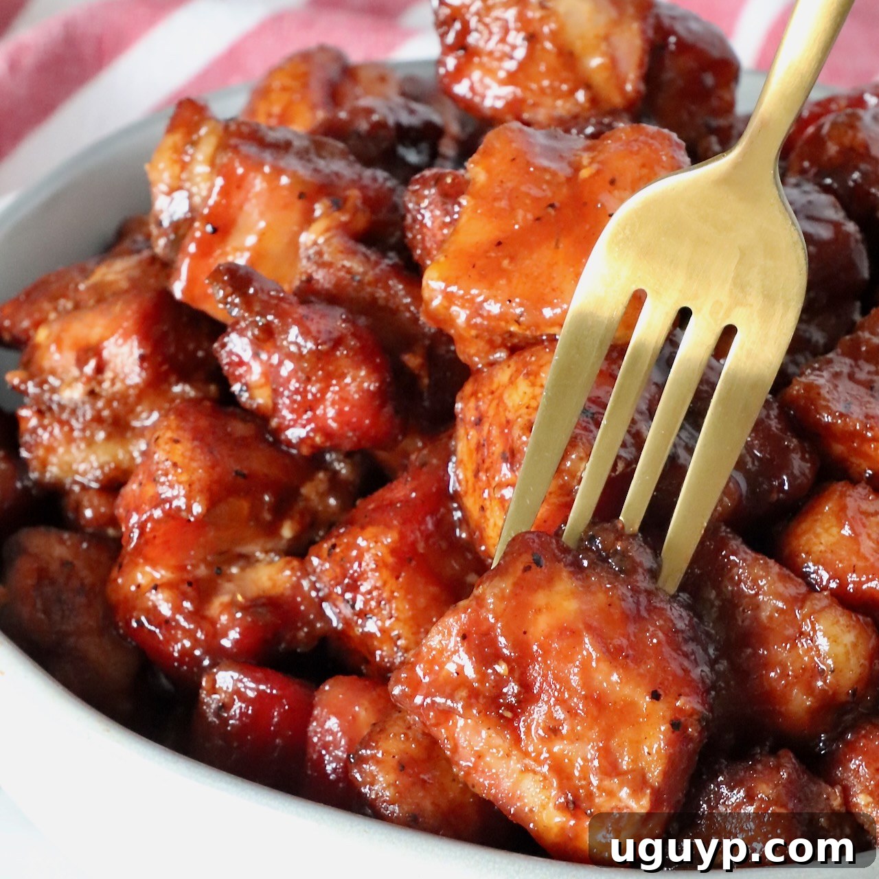 Smoked Pork Belly Burnt Ends in a bowl with a fork, showing their tender texture.