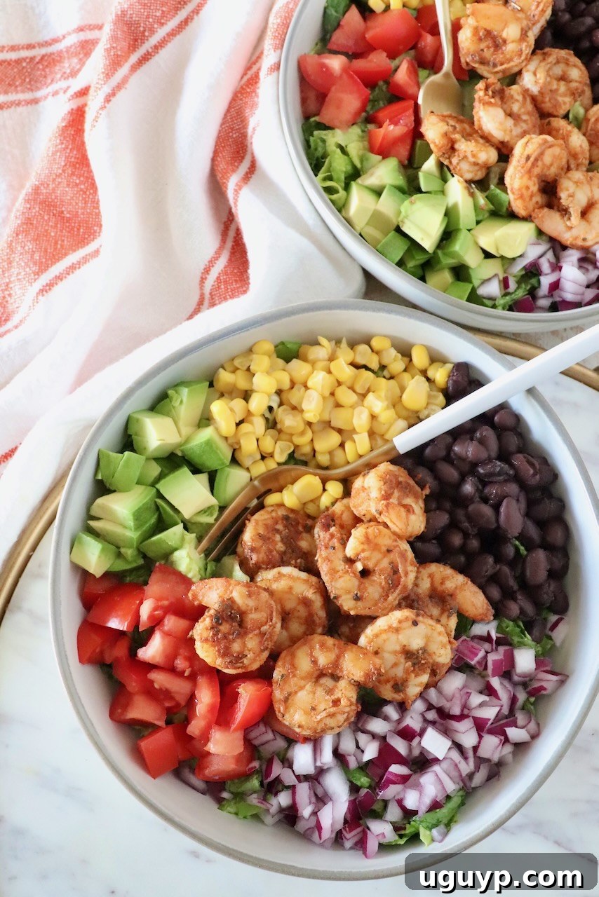 A beautifully plated Mexican shrimp salad in a bowl, garnished with fresh cilantro and a fork ready to enjoy.