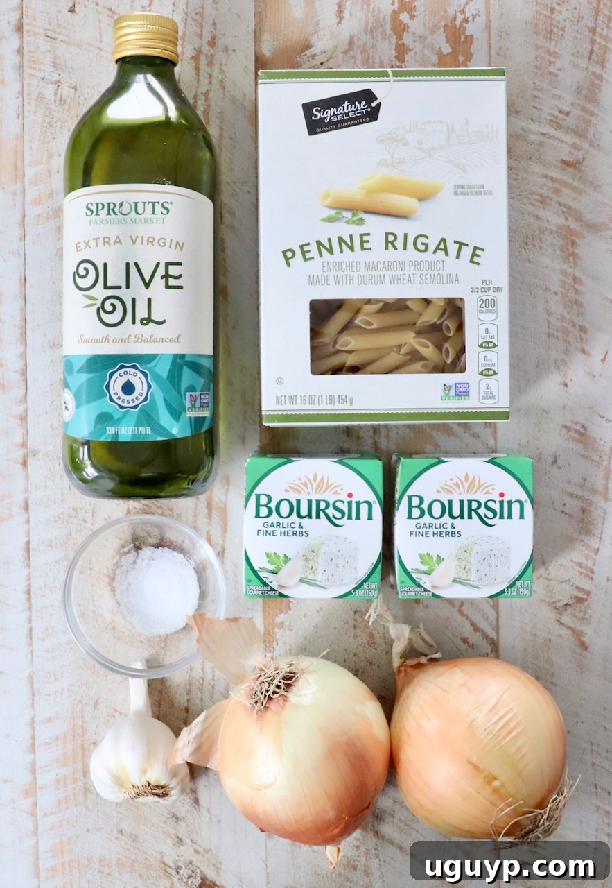 Ingredients on a wooden surface: olive oil, penne pasta, two packs of Boursin cheese, salt, garlic bulb, and two onions.