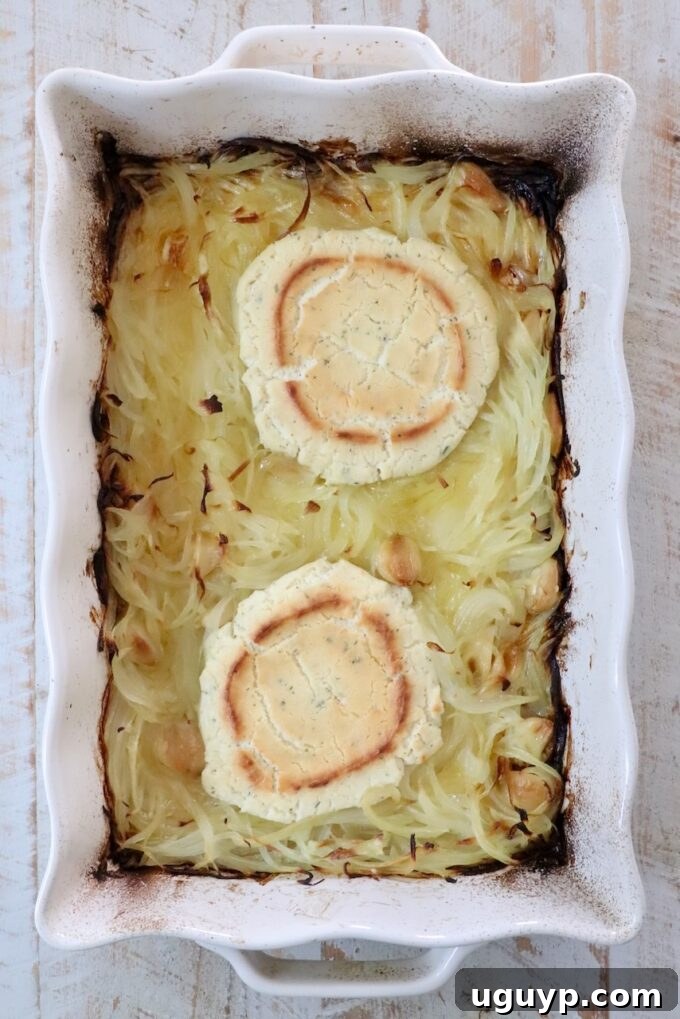 baked rounds of boursin cheese and caramelized onions in a white casserole dish