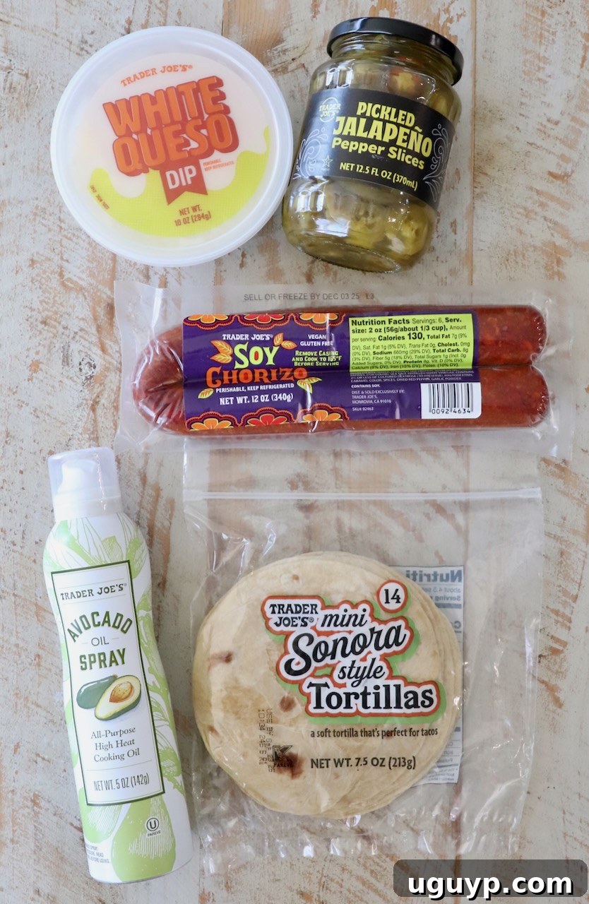 A beautifully arranged flat lay showcases essential Trader Joe's ingredients for crispy chorizo tacos on a warm wooden surface. Featured items include a container of creamy white queso dip, a jar of tangy pickled jalapeños, a package of spicy soy chorizo, a stack of small flour tortillas, and a can of avocado oil cooking spray.