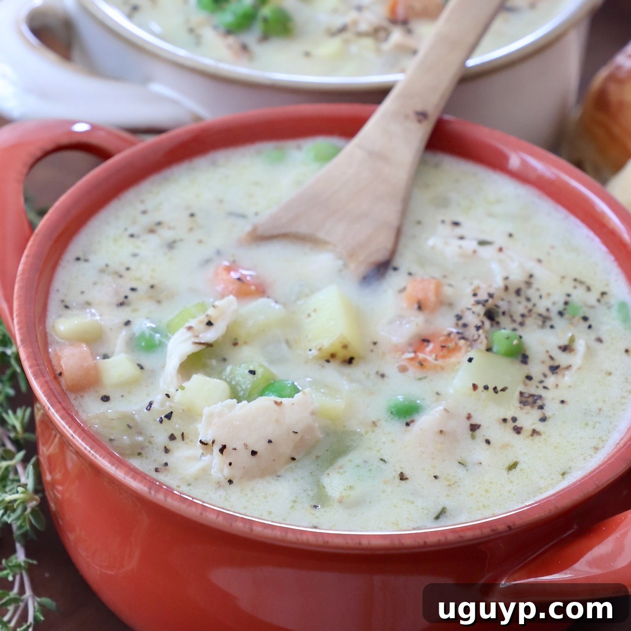 Comforting Chicken Pot Pie Soup served in a bowl with a spoon, offering a warm and savory meal.